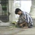 Boy crouching near the ground with a small amount of food